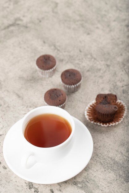 Mini brownie al cioccolato e tazza di tè nero su pietra.