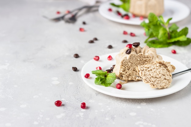 Mini cheesecake vegane con caffè e banana guarnite con chicchi di caffè, melograno e menta