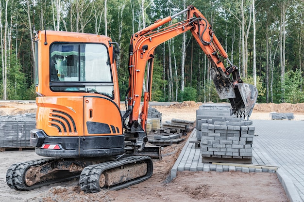 Mini escavatore in cantiere. Macchine edili compatte per movimento terra.