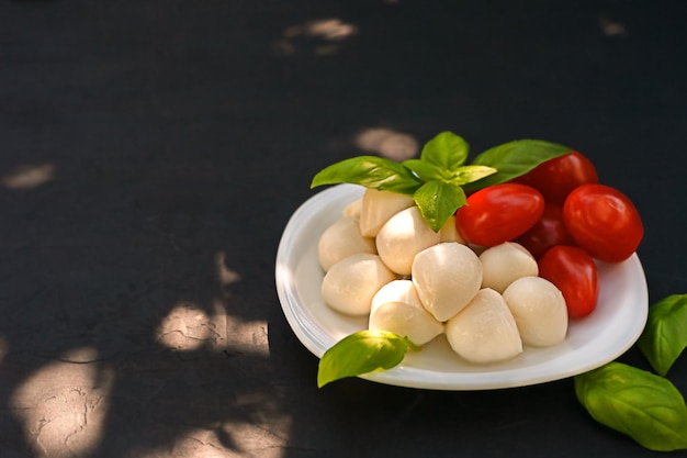 Mini mozzarella con pomodori e basilico su un piatto