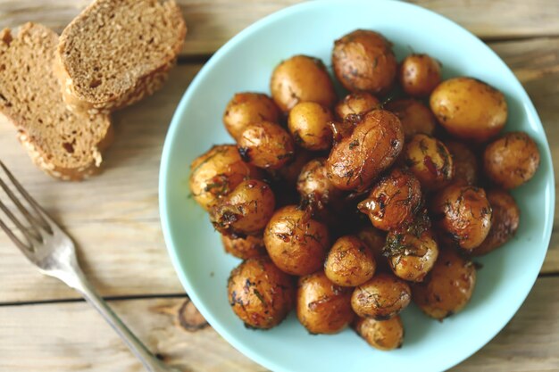 Mini patate arrosto con la buccia su un piatto.