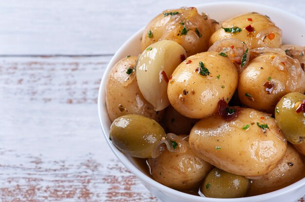 Mini patate marinate fatte in casa in una ciotola bianca. Copia spazio