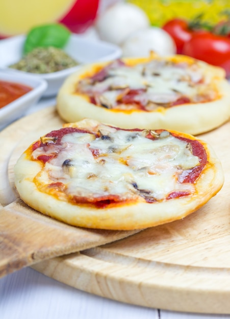 Mini pizza con salame, pancetta, funghi e formaggio