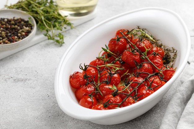 Mini pomodorini al forno con olio aglio e timo in teglia bianca Dieta idea vegana