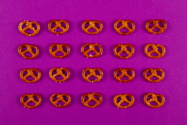 Mini pretzel in quattro file e cinque colonne giacciono su sfondo viola
