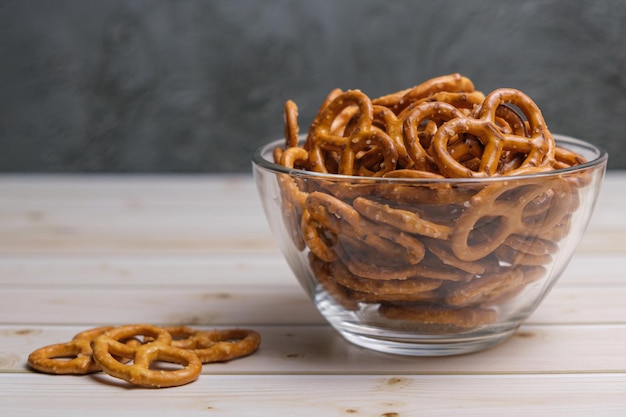 Mini salatini salati in una ciotola di vetro profonda su un tavolo di legno