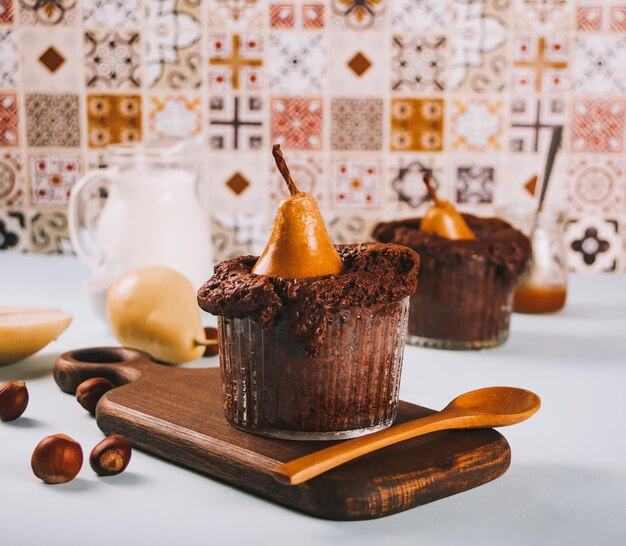 Mini torta di biscotti speziati autunnali dolci fatti in casa in tazza con pera intera e noci