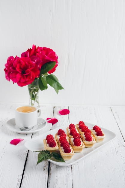 Mini tortine con ricotta e lamponi freschi e una tazza di caffè