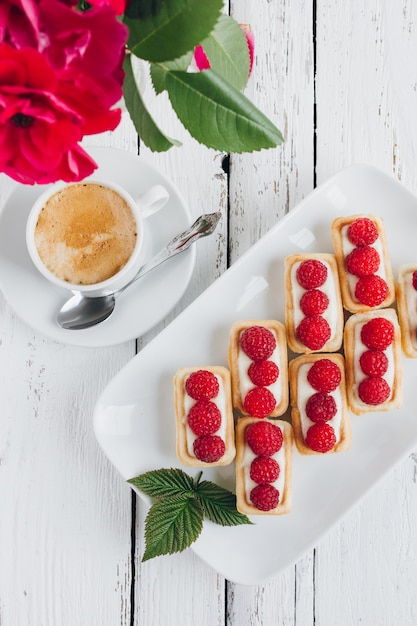 Mini tortine con ricotta e lamponi freschi e una tazza di caffè