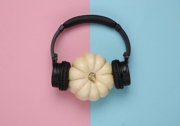 Mini zucca bianca con cuffie stereo su sfondo blu rosa