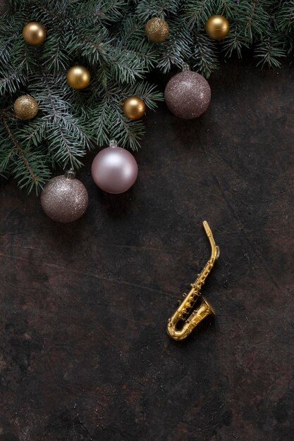 Miniatura di sassofono dorato copia rami di abete e palle rosa di Natale