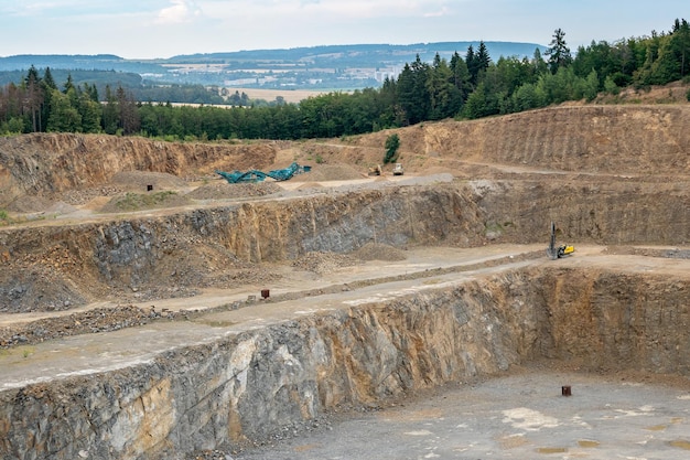 Miniera a cielo aperto con molti macchinari Estrazione nella cava di granito