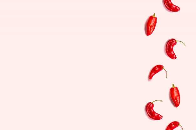 Minimo concetto di cibo. Disposizione creativa di peperoncino su fondo rosa.