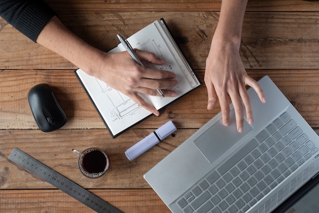 Ministero degli interni, lavoro da casa, azione delle mani della donna che lavora con il computer, note, caffè. sul tavolo di legno.