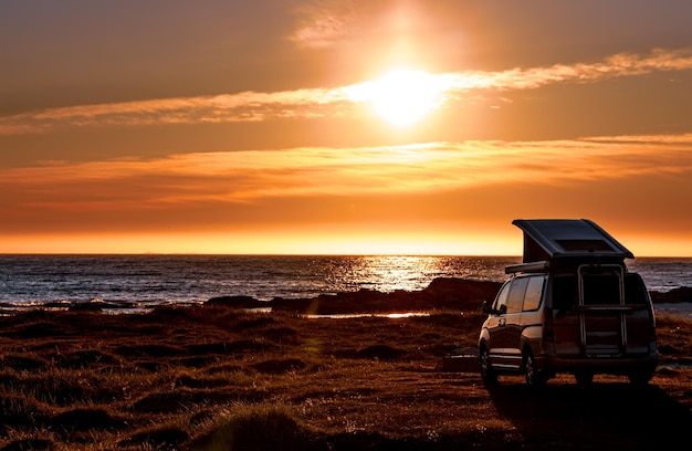 Minivan camper sulla spiaggia al tramonto. Bella natura Norvegia paesaggio naturale Spiaggia delle Lofoten.