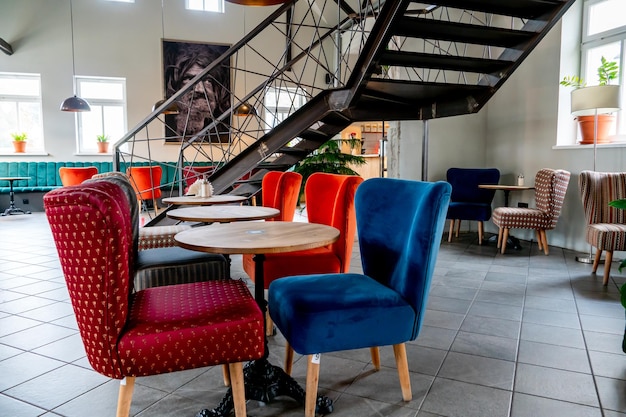 Minsk Bielorussia 22 giugno 2022 Un ristorante moderno e accogliente con sedie imbottite colorate e comodi divani Design insolito del caffè con pareti in cemento grezzo e travi decorative in legno sul soffitto