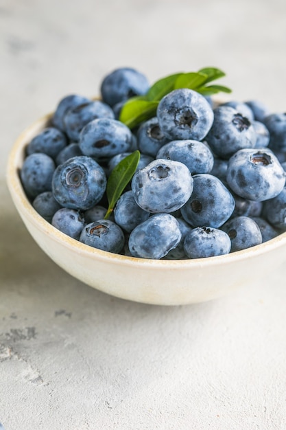 Mirtilli appena raccolti in una ciotola Bacche succose e fresche con foglie verdi