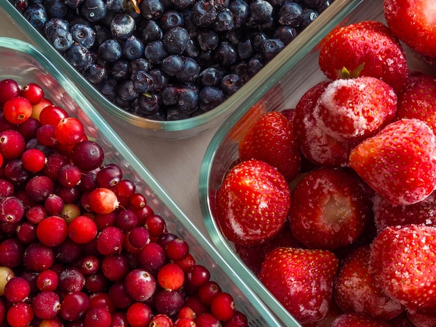 Mirtilli di bosco sfondo di mirtillo rosso e fragola in ciotole di vetro