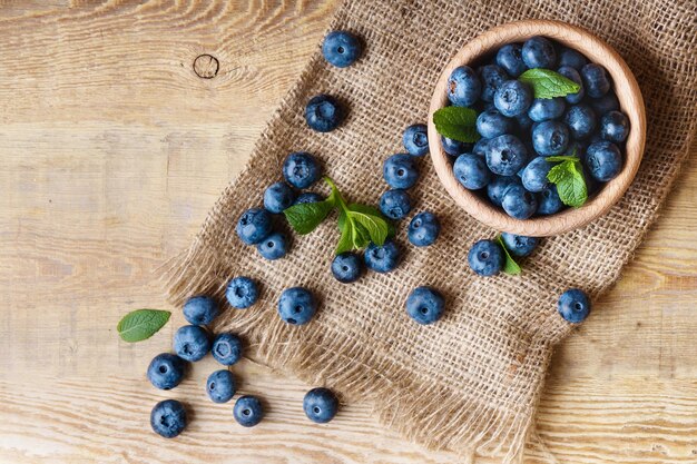 Mirtilli freschi e succosi appena colti con foglie di menta verde