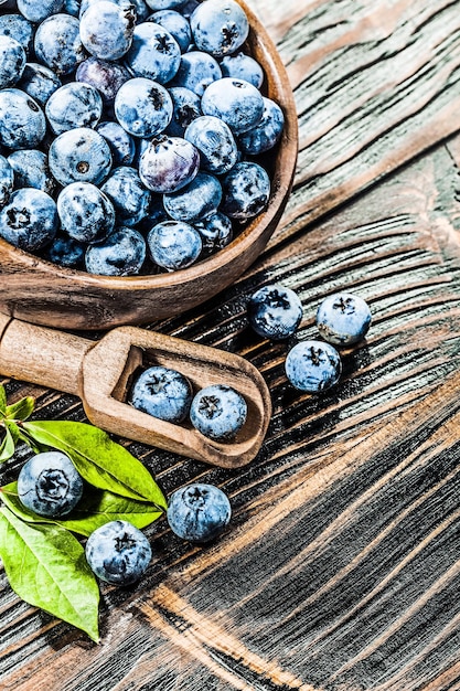 Mirtilli freschi in una ciotola di cucchiaio di legno