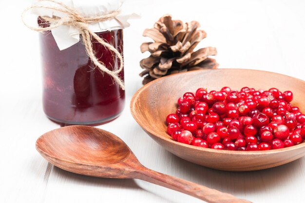 Mirtilli rossi in ciotola di legno e marmellata