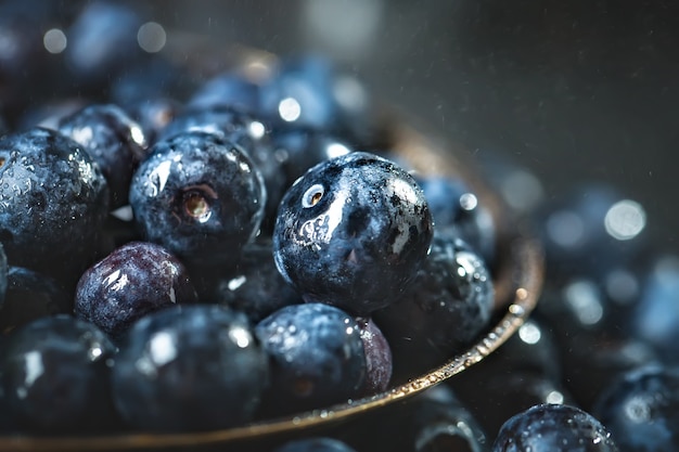 Mirtilli succosi e freschi con le foglie verdi sulla tavola rustica