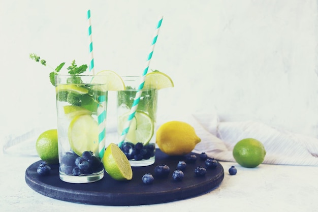 Mirtillo lime e foglie di menta bevono ingredienti per mojito su sfondo chiaro