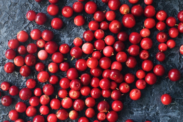 Mirtillo rosso fresco organico crudo o mirtillo rosso sul concetto di stile di vita sano della tavola di pietra scura