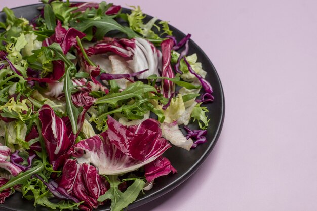 Miscela di verdure a foglia multicolore in banda nera. Cibo vegano. Mangiare pulito. Copia spazio