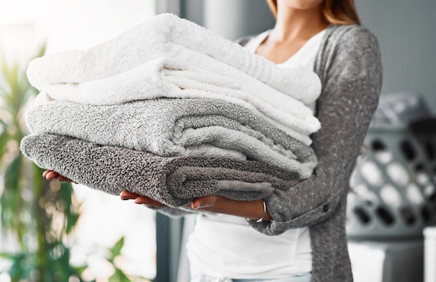 Missione compiuta asciugamani freschi e puliti Inquadratura ritagliata di una giovane donna irriconoscibile che fa il bucato a casa