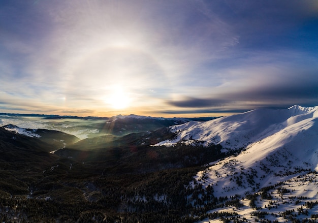 Mistica veduta aerea delle piste da sci delle colline di montagna e degli alberi coperti di neve