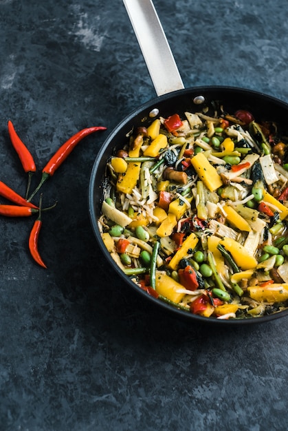 Misto di verdure fresche asiatiche, wok thailandese in una padella nera sul nero