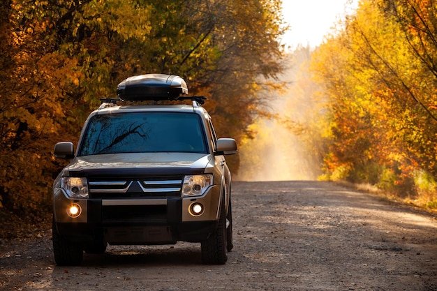 Mitsubishi Pajero sulla strada panoramica autunnale nella foresta