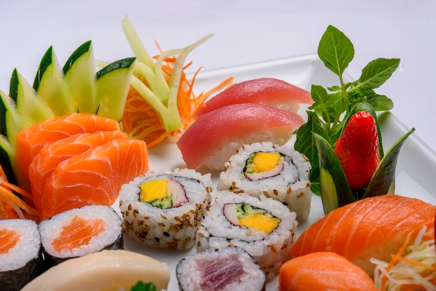 Mix di cibo giapponese tra cui sushi e sashimi su piatto bianco