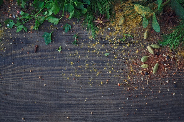 Mix di erbe fresche e assortimento di spezie su fondo di legno. Prezzemolo fresco, timo, aneto e foglie di menta. Vista dall'alto con spazio per la copia