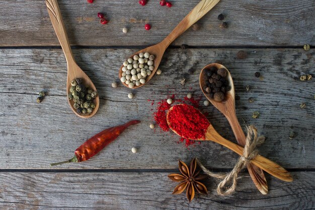 Mix di peperoni in cucchiai di legno su tavola rustica spezie indiane colorate stile di vita sano cucina asiatica vista dall'alto