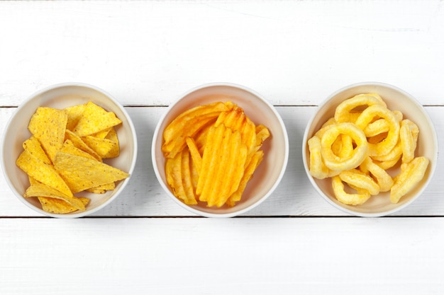 Mix di snack: salatini, crackers, patatine e nachos sul tavolo