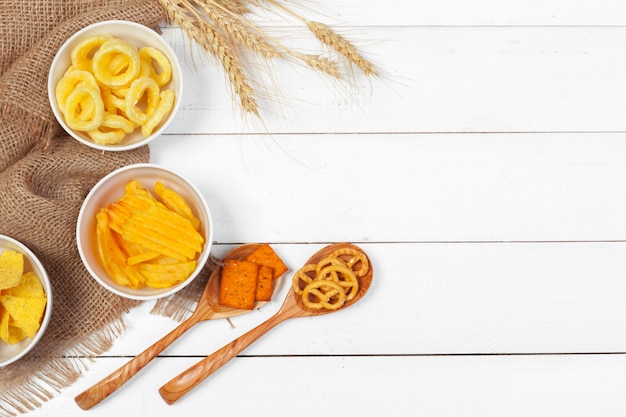 Mix di snack: salatini, crackers, patatine e nachos sul tavolo