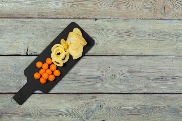 Mix di snack: salatini, crackers, patatine e nachos sul tavolo