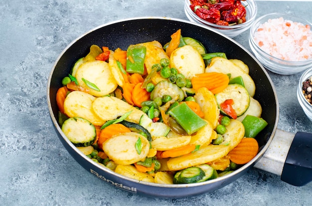 Mix di verdure biologiche surgelate fritte in padella. Foto dello studio.