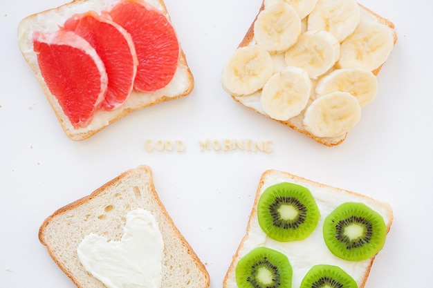 Mix luminoso di panini per colazione frutta, verdura, iscrizione di pesce buongiorno