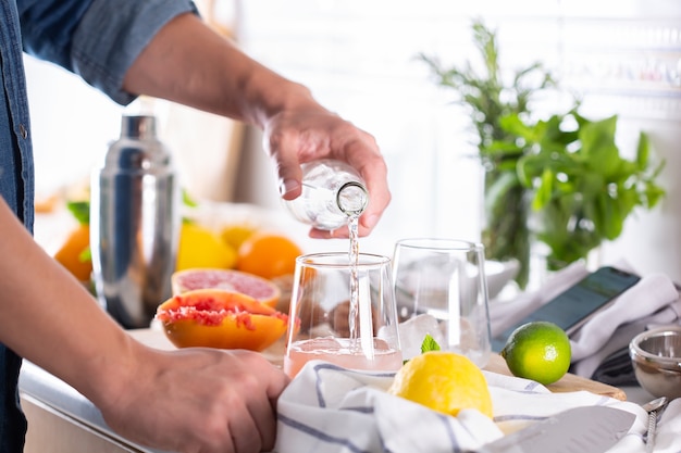 Mixologist che prepara cocktail rinfrescanti con seltz duro a casa