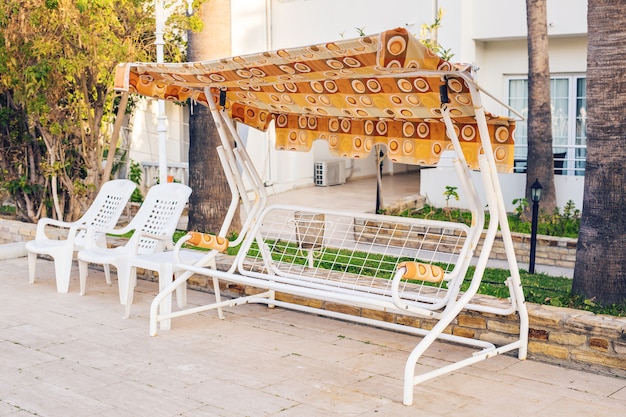 Mobili da esterno bianchi. Le sedie a sdraio nel giardino dell'hotel vi invitano al relax.