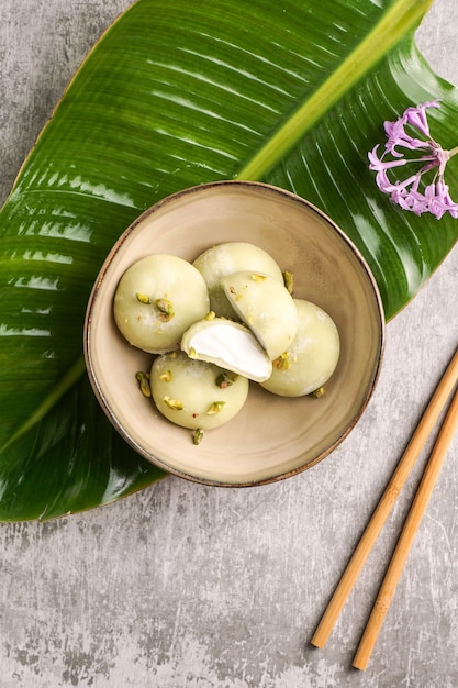 Mochi con gelato al pistacchio, cibo dolce tradizionale giapponese sullo sfondo grigio