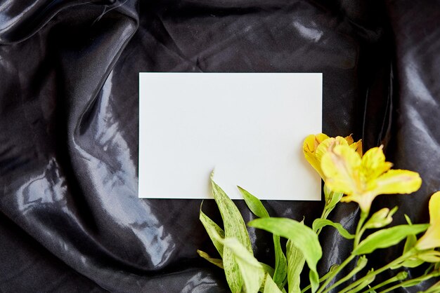 Mock up cartoleria tra fiori su sfondo nero Concetto femminile estivo Bellezza elegante