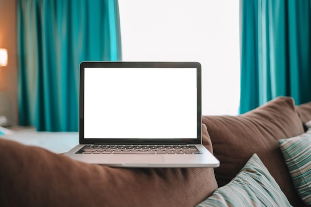 Mock up laptop schermo vuoto sul letto per pubblicità e testo.