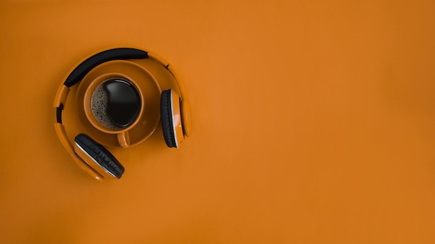 Mock up telefono capo, tazza di caffè e copia spazio su sfondo arancione.