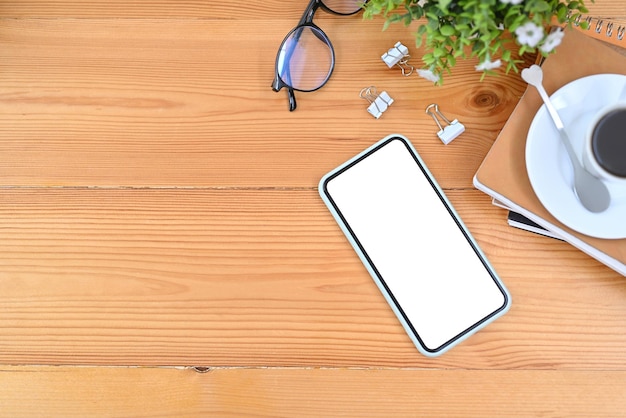Mock up telefono cellulare con schermo bianco su sfondo di legno