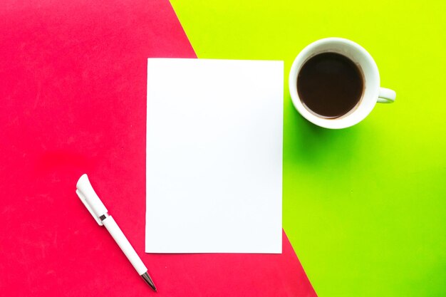 Mockup bianco tazza di caffè vuota e penna su sfondo geometrico rosso e verde Spazio di copia di vista superiore piatto