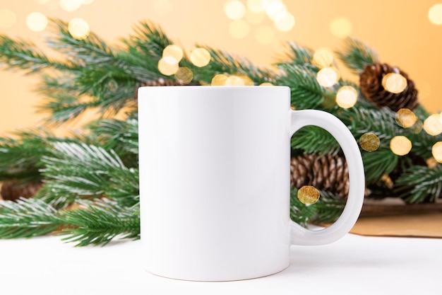 Mockup con tazza in ceramica bianca e albero di Natale e tazza vista frontale bokeh